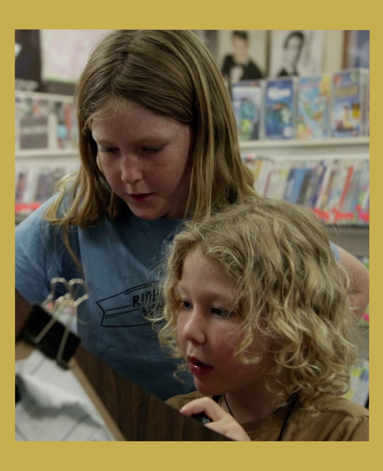 Image has a gold border and is of two young brothers playing a 1980s arcade machine at Bellingen Video Connection from the documentary Return Chute: The survival of a small town video store
